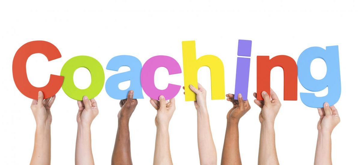 hands holding up multi-coloured letters that spell the word Coaching